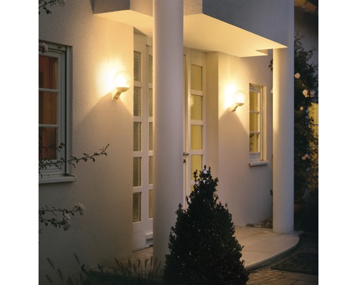 Osvetlená fasáda domu s dvoma okrúhlymi nástennými svietidlami