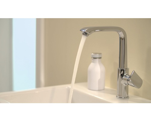 Chrómová vodovodná batéria s tečúcou vodou v umývadle