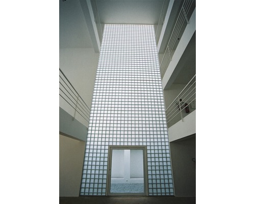 Interiérový pohľad na budovu so stenou zo sklenených tvárnic a dverami