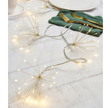 Scéna so svetelnou reťazou v tvare hviezdy, tanierom, príborom a šálkou