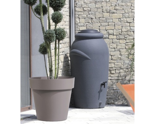 Plastový sud na dažďovú vodu s kohútikom vedľa kvetináča