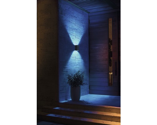 Osvetlený vstupný priestor s vonkajšou nástennou lampou, vchodovými dverami a schodmi