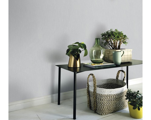 Pohľad na izbu so stolom, rastlinami a dekoráciou pred jednofarebnou stenou