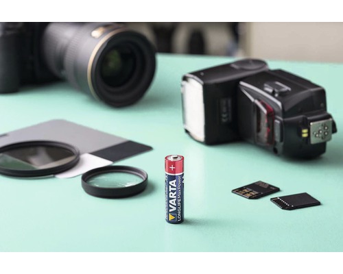 Batéria Varta s kamerami a fotografickým príslušenstvom v pozadí