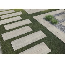 Záhradný chodník s obdĺžnikovými dlaždicami s vzhľadom dreva na trávniku