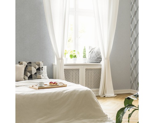 Svetlá spálňa s posteľou, závesmi a stenou so štruktúrovanou tapetou