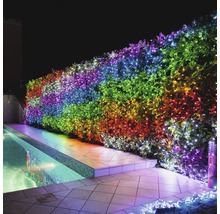 Záhradný živý plot s farebnou svetelnou reťazou vedľa bazéna