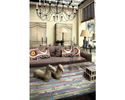 Obývacia izba s hnedou pohovkou, dreveným konferenčným stolíkom, dekoračnými predmetmi a lustrom.