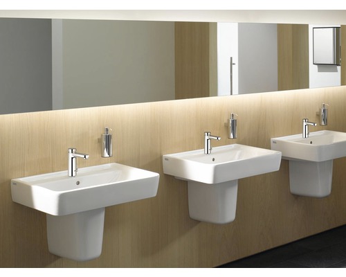 Tri biele umývadlá s batériami a dávkovačmi mydla v kúpeľni.