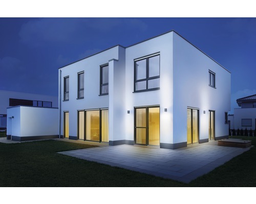 Moderný rodinný dom s vonkajším osvetlením v záhrade v noci