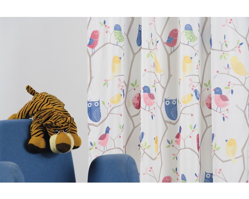 Záves s dizajnom vtákov a sov vedľa modrého kresla s plyšovým tigrom