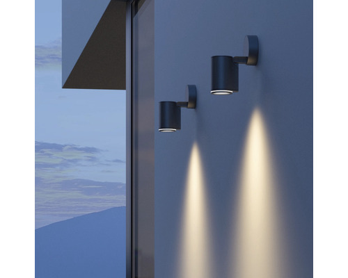 Dve valcové nástenné lampy osvetľujú stenu domu