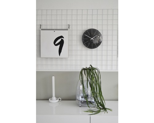 Dekoratívne izbové prostredie s kalendárom, hodinami a izbovou rastlinou na skrinke