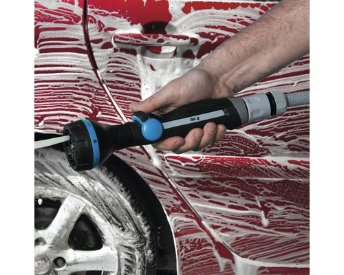 Osoba umýva auto pomocou viacúčelovej striekacej pištole.