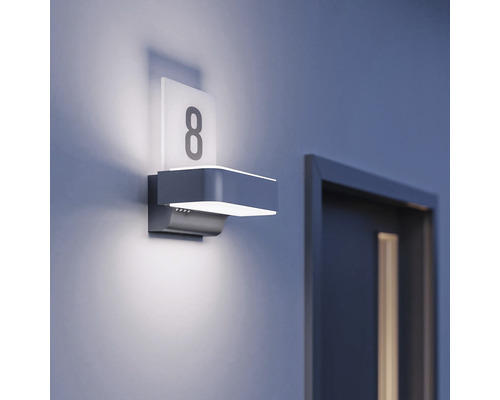 Osvetlená domová tabuľa s číslom 8 vedľa dverí