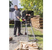 Muž obsluhuje pílku na palivové drevo na rezanie dreva vonku.