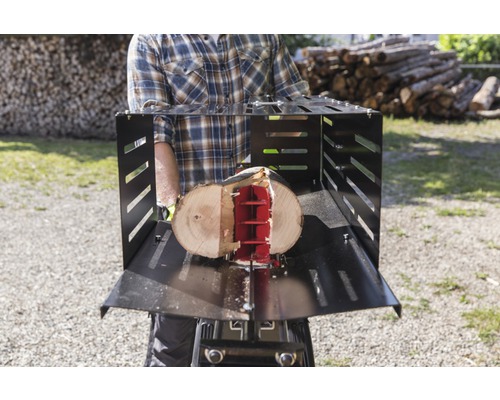 Muž štiepa drevo pomocou štiepačky