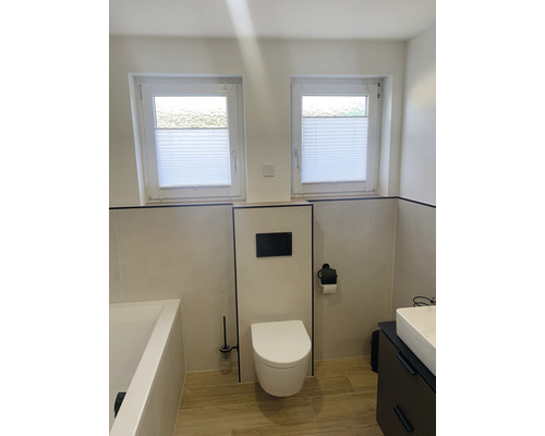 Svetlá kúpeľňa s toaletou, umývadlom, vaňou a dvoma oknami s plisovanými žalúziami