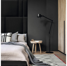 Spálňa s posteľou, nočným stolíkom, stojacou lampou a kobercom