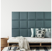 Nástenné panely ako čelo postele nad matracom na drevenej palete s vankúšmi a dekou