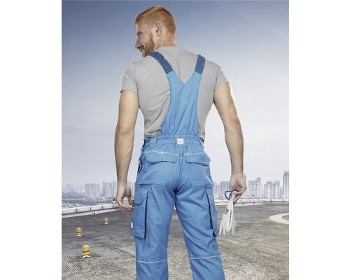 Muž v modrých pracovných nohaviciach a montérkach, pohľad zozadu