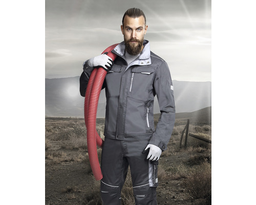 Muž v sivom pracovnom odeve s červenou hadicou cez rameno