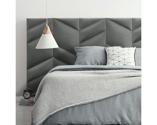 Spálňa s čalúneným čelom postele, posteľou a závesnou lampou pre pokojnú atmosféru