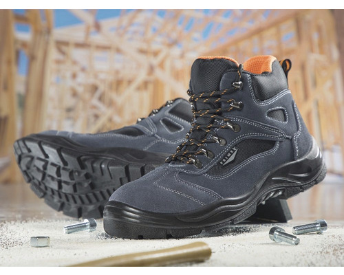 Pár sivých bezpečnostných topánok Primek pred drevenou konštrukciou