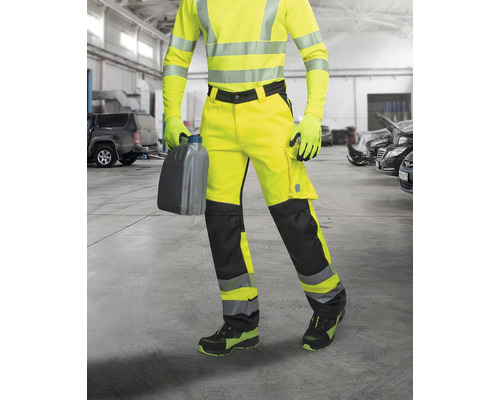 Osoba v ochrannom odeve s kanistrom v dielni.