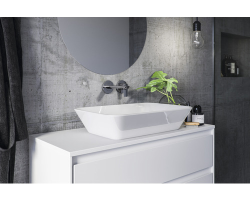 Moderná kúpeľňa s umývadlom na dosku, okrúhlym zrkadlom a betónovou stenou