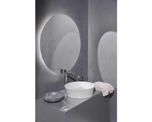 Kúpeľňa s okrúhlym zrkadlom, umývadlom na dosku, batériou a umývadlovou skrinkou