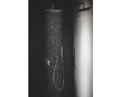 Dažďová sprcha s ručnou sprchou a tečúcou vodou v kúpeľni.