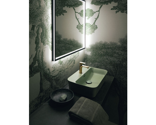 Kúpeľňa s osvetleným zrkadlom, umývadlom, batériou, miskou na mydlo a uterákom