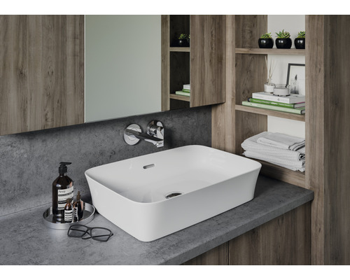 Moderná kúpeľňa s umývadlom na dosku, batériou, zrkadlom a drevenými policami.