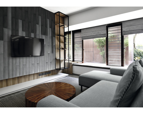 Obývacia izba s pohovkou, televízorom a regálom.