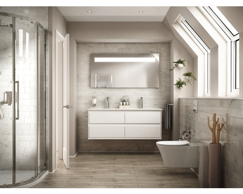 Svetlá kúpeľňa so sprchou, umývadlom, zrkadlom a toaletou pod strešnými oknami.