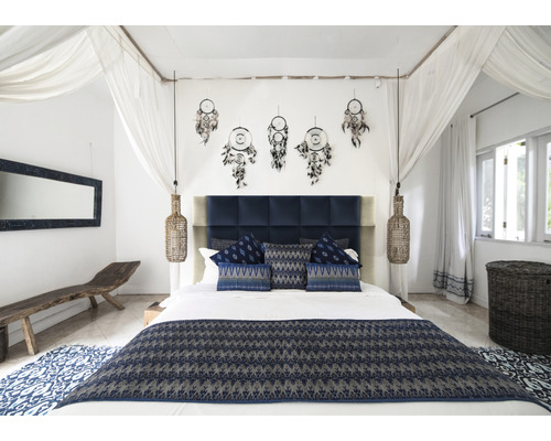 Spálňa s manželskou posteľou, nočnými lampami, lapačmi snov a modrým textilom