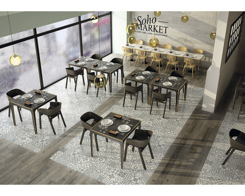 Interiérová fotografia reštaurácie so stolmi, stoličkami a podlahovými dlaždicami so vzorovaným dizajnom.