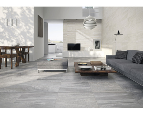 Svetlá obývacia izba so sivou dlažbou, pohovkou a dreveným stolom