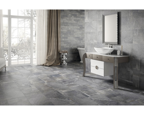 Moderná kúpeľňa so sivými obkladmi stien a podlahy, umývadlovou skrinkou, zrkadlom a vaňou.