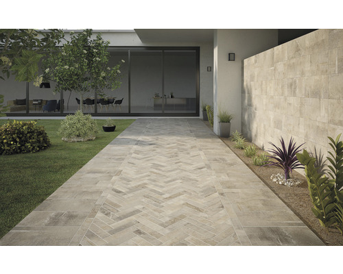 Vonkajší priestor s položenou dlažbou s kamenným vzhľadom a ozdobným vzorom rybej kosti na záhradnom chodníku.