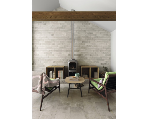 Obývacia izba s kachľami, dlažbou, dvoma kreslami a malým stolom