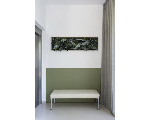 Nástenná dekorácia s umelými rastlinami nad lavicou vo svetlej miestnosti