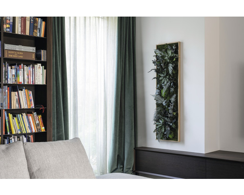 Dekoratívny nástenný panel s umelými rastlinami v obývacej izbe.