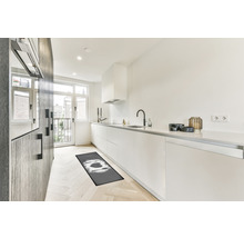 Moderná kuchyňa s kuchynským behúňom, bielymi skrinkami a drevenou podlahou