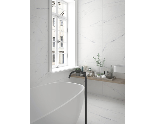 Svetlá kúpeľňa s obkladmi v mramorovom vzhľade, vaňou a oknom