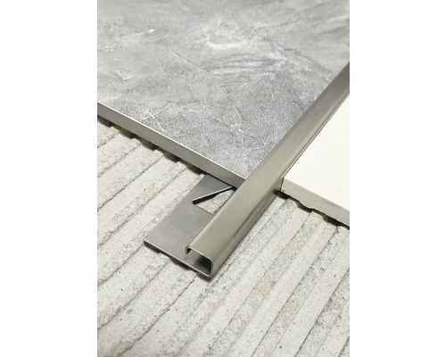 Kovová dlaždicová lišta medzi dvoma dlaždicami