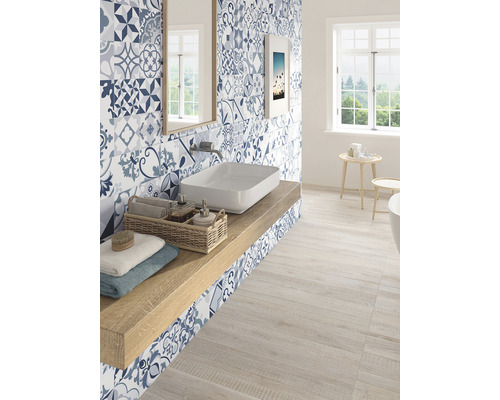 Svetlá kúpeľňa s modrými vzorovanými obkladmi, umývadlom a drevenou podlahou