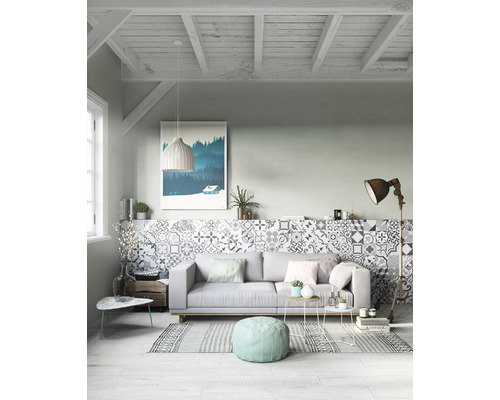 Svetlá obývacia izba s pohovkou, vzorovanými dlaždicami a dekoráciami pre útulnú atmosféru