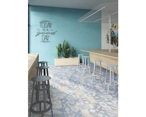 Interiér s barovými stoličkami, pultom a podlahovými dlaždicami s rôznymi vzormi